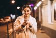 a girl standing and using mobile phone